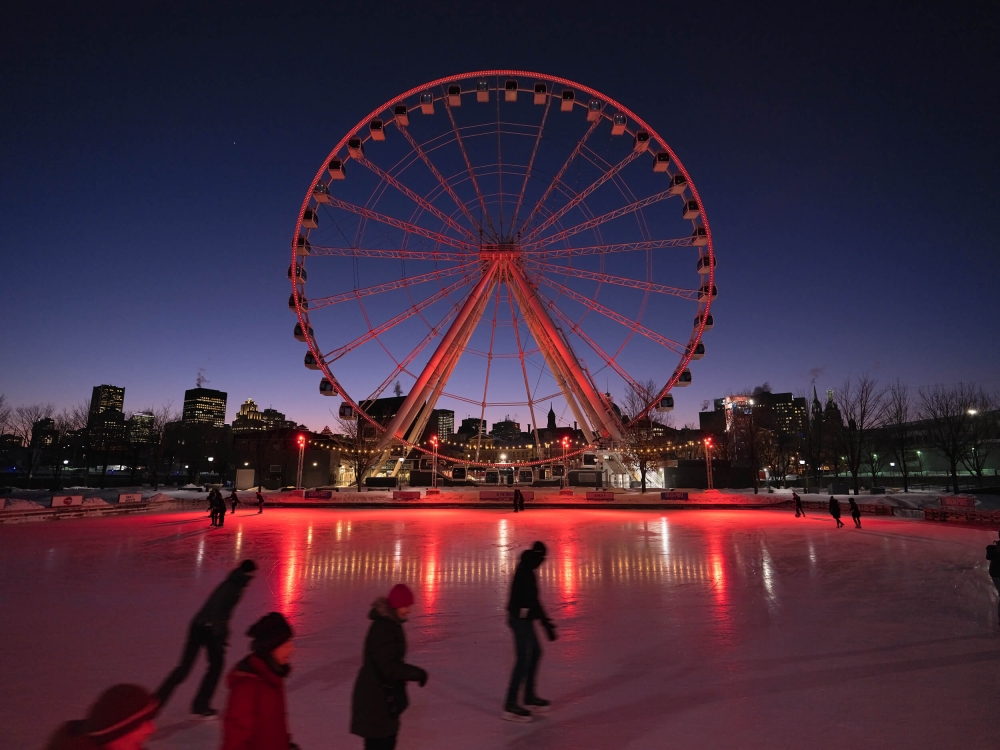 Montreal nightscape with ice skating in the foreground and a ferris wheel in the background