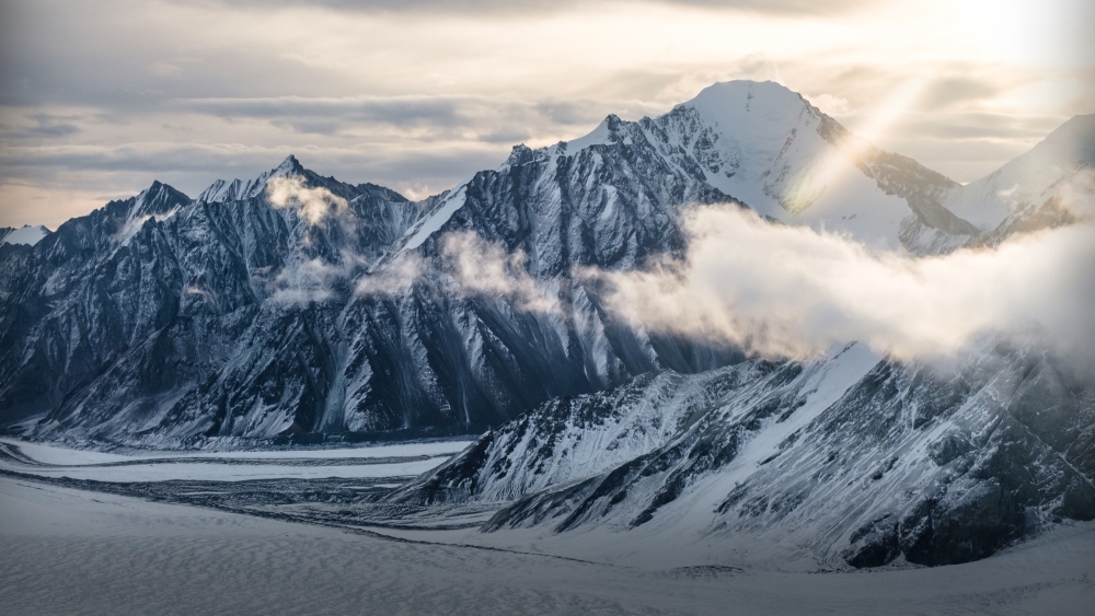 yukon white snowy mountains with the sun gleaming above